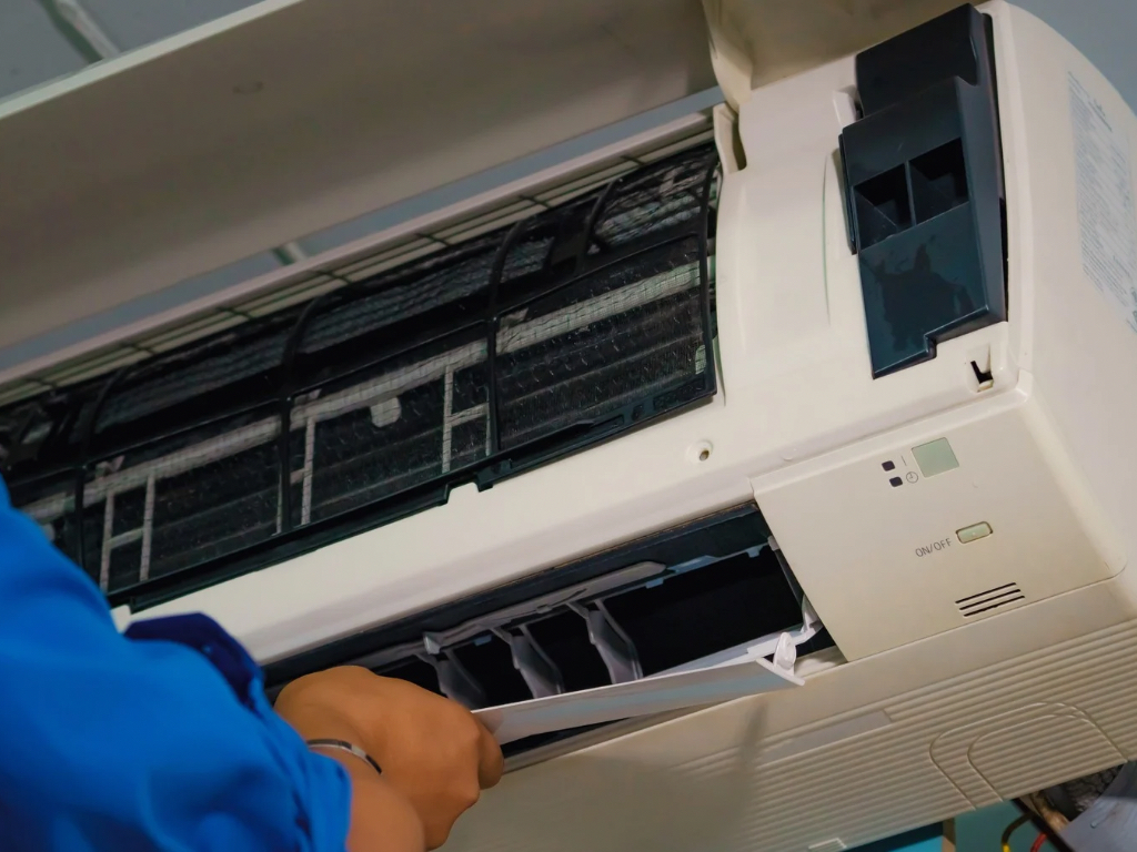 A man repairing an air conditioning unit